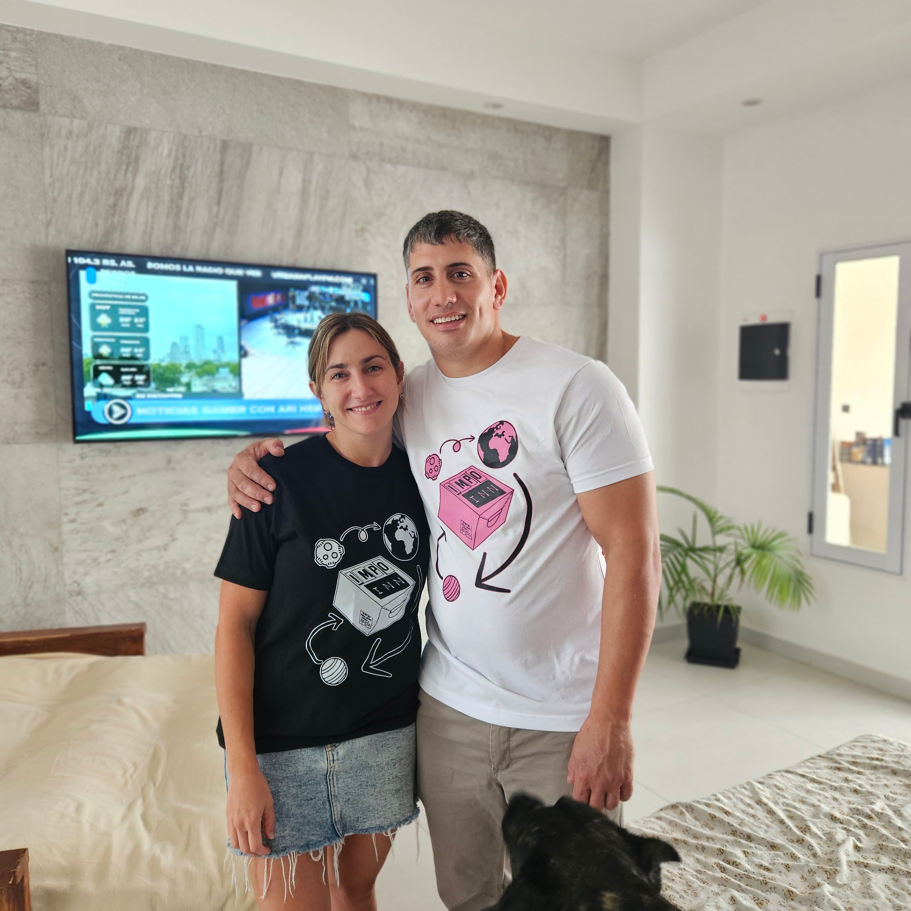 Pareja empresaria con camisetas Impo INN en hogar
